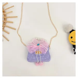 Detail der lila Kindertasche mit rosa Schleife, Perlengriff und goldener Kettenriemen
