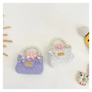 Detailed view of mini girls handbag with pearl handle and floral charm in purple and white