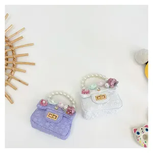 Detail of girls mini bags with 3D floral accents and elegant pearl chain handles