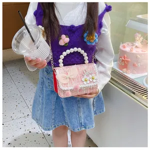 Pink tweed kids crossbody bag with pearl handle and ribbon bow shown in a dessert shop