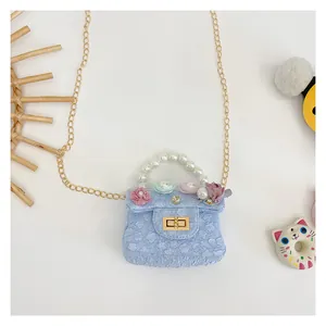 Detail of light blue girls mini bag with 3D floral textures and pearl handle