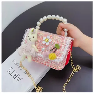 Detail of pink tweed girl handbag with pearl handle and plush bunny pendant