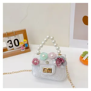 Detail of white textured fabric girl purse with 3D flowers and pearl handle