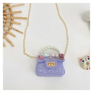 Detail of lavender floral girls handbag with pearl handle and golden chain strap