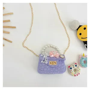 Detail of lavender mini bag with pearl handle, pink flower, and gold chain strap