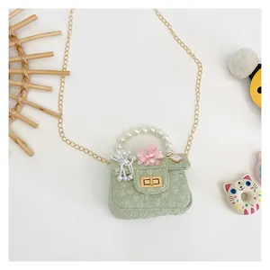 Detail of mint green mini bag featuring pearl handle, floral decor, and perfume bottle charm