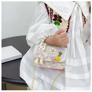 Detail of pink sequin tweed girl's crossbody bag with pearl handle and rabbit doll