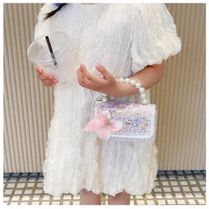 Detail of lavender sequin girls handbag with pink bow, pearl handle, and lace trim