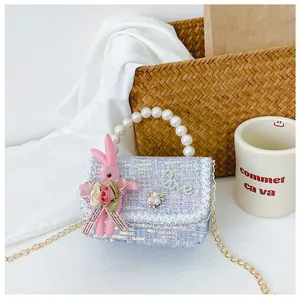 Detail of tweed girl's bag with pearl handle, pink plush bunny and Love lettering