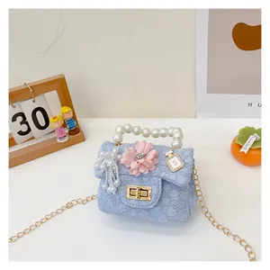 Detail of light blue girls' crossbody bag with pearl handle and 3D floral texture