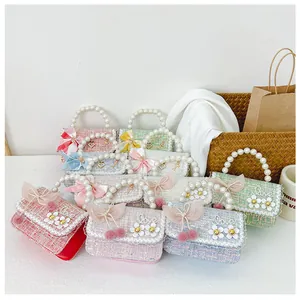 Detail of tweed children's mini handbag with pearl handle, ribbon bow, and flower accents