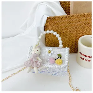 Detail of light blue sequined kids crossbody bag with lace and pearl handle strap
