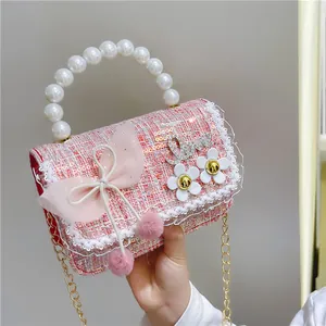 Pink tweed kids handbag with pearl handle, tulle bow, and floral decoration