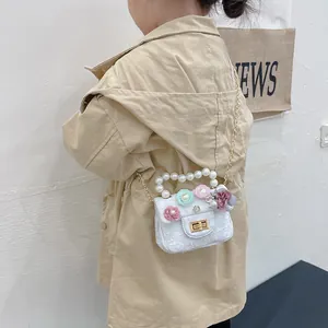 Fashionable mini girls crossbody bag with floral accents and pearl handle on model