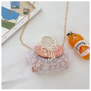 Detailweergave van de roze crossbodytas met lovertjes, parelhandvat en kantafwerking