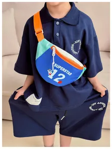 Detail showing kids navy polo set paired with a colorful superstar bear crossbody bag