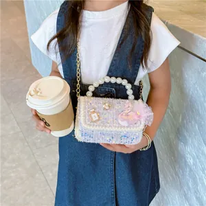 Girl's tweed crossbody bag with pearls and sequins worn by model on marble background