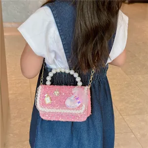 Pink sequin crossbody bag with pearl handle and lace detail worn by a child
