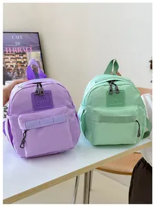 Gros plan de sacs à dos en nylon violet et vert menthe avec étiquettes en caoutchouc