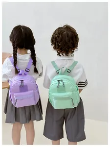 Vue arrière d'enfants portant des mini sacs à dos en nylon violet et vert menthe frais