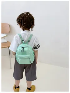 Détail du sac à dos enfant vert menthe avec logo GIDL CAES et texture nylon durable