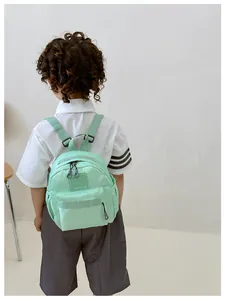 Détail d'un sac à dos enfant vert menthe montrant la poche avant zippée durable