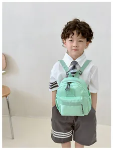Détail d'un sac à dos enfant vert menthe en nylon léger avec poche avant et logo gidl caes