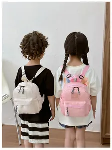 Enfants portant des mini sacs à dos mignons en nylon rose et crème pour l'extérieur