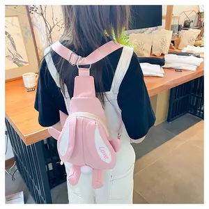 Detail of pink cartoon rabbit crossbody bag with long plush ears and soft furry pompom