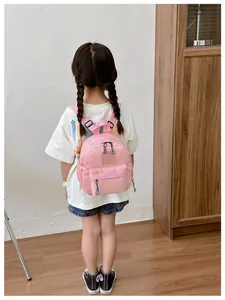 Mini sac à dos rose pour enfants porté par un enfant pour montrer la taille réelle
