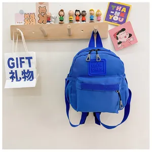 Gros plan du sac à dos bleu en nylon pour enfant avec poche zippée à l'avant