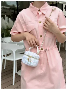 Détail d'un mini sac à paillettes avec fermeture éclair fleurie et bandoulière