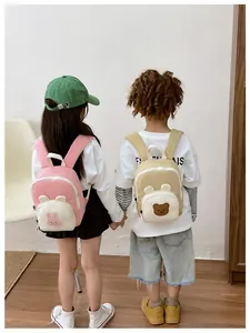 Detail view of pink rabbit and khaki bear canvas backpacks on toddlers in a bright room