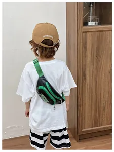 Vista posteriore del bambino con borsa a tracolla nera e verde e cappellino coordinato