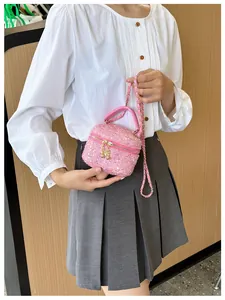 Gros plan d'un sac bandoulière en tweed rose à paillettes avec chaîne élégante sur modèle