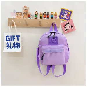 Détail du sac à dos violet pour enfants accroché avec des accessoires décoratifs mignons