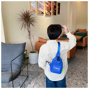 Close-up of blue kids chest bag with Trend print and adjustable strap in a cafe