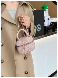 Mini sac vanity en tweed rose à paillettes avec bandoulière dorée sur un trench beige