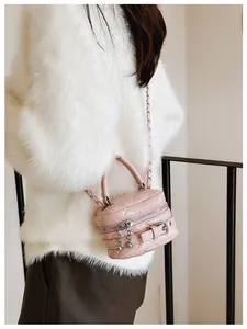 Detail van roze gewatteerde mini-crossbodytas met zilveren ketting op model met bontjas