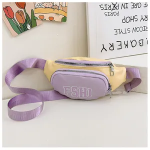 Dettaglio del marsupio per bambini bicolore con scomparti a zip e stampa di lettere