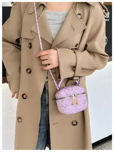 Détail du sac à bandoulière matelassé à paillettes violettes et breloques fleurs dorées