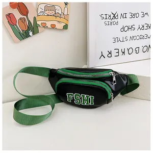 Dettaglio del marsupio bimbo in pelle nera con cerniere verde lime e stampa di lettere