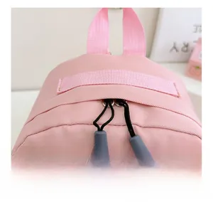 Gros plan sur les doubles fermetures éclair fluides et la sangle du sac à dos enfant rose