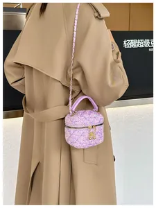 Détail du mini sac boîte à paillettes violettes matelassées avec chaîne dorée et fleur