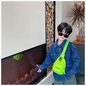 Detail view of the neon green kids crossbody bag featuring the black Trend print design
