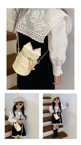 Detail of cream quilted bucket bag with bow, gold chain, and heart love embroidery