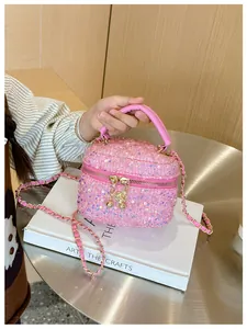 Gros plan sur les paillettes roses avec chaîne dorée et breloque florale du sac