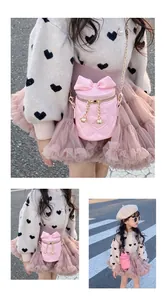 Close-up of pink bucket bag with heart quilting, bow detail and gold chain strap