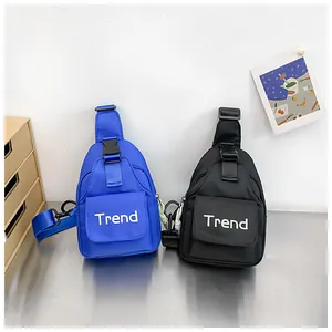 Detail of blue and black nylon kids crossbody bags with Trend lettering and buckle strap