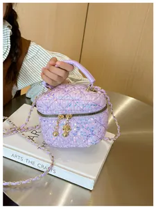 Détail du mini sac à paillettes matelassé violet avec breloques dorées et chaîne